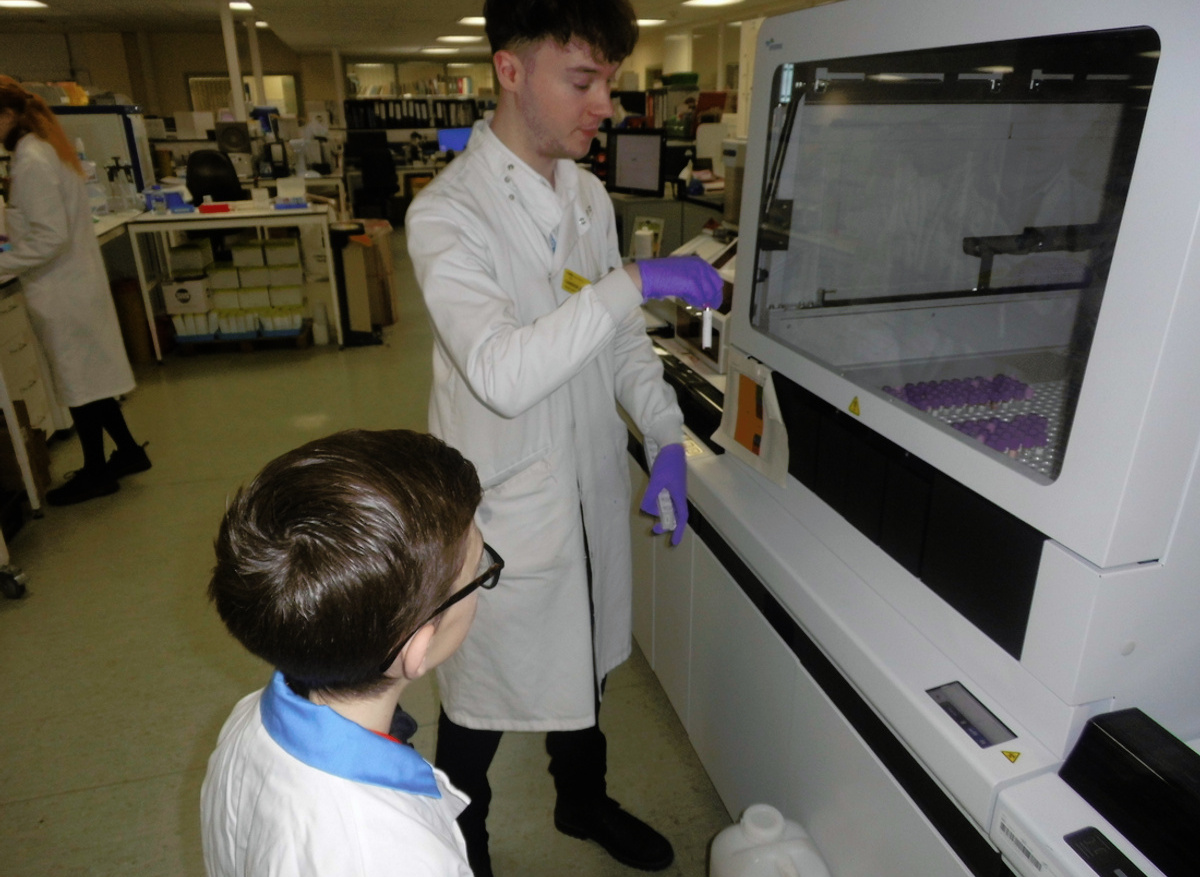 Watching scientist load samples into analyser