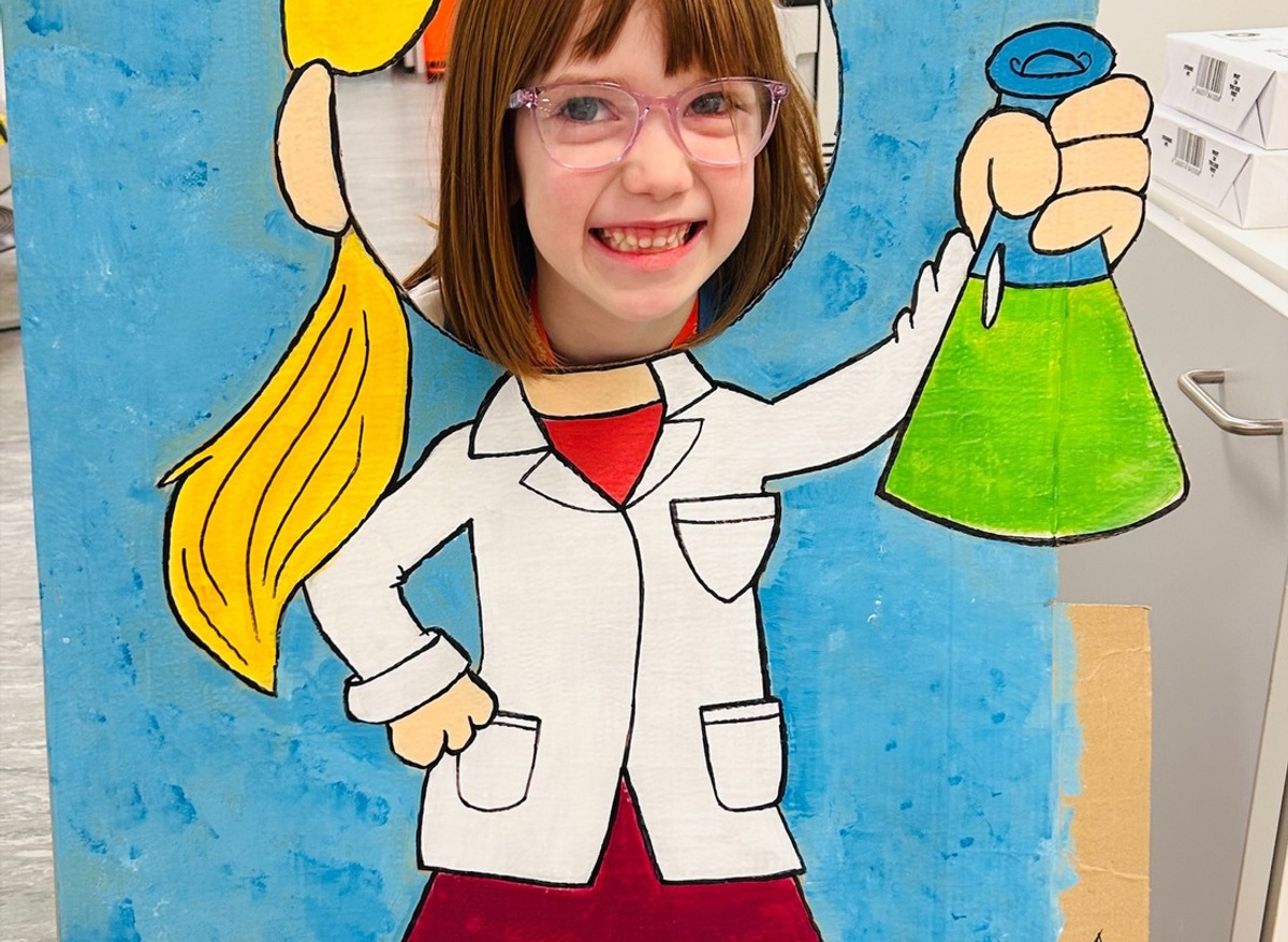 Beatrice posing with the scientist display board