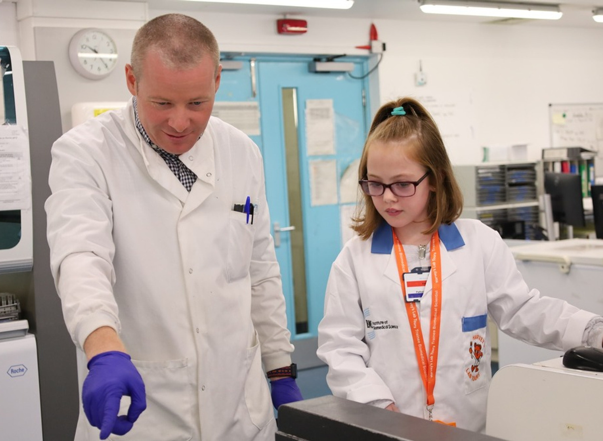 Peyton listens as a biomedical scientist shows her around the lab.